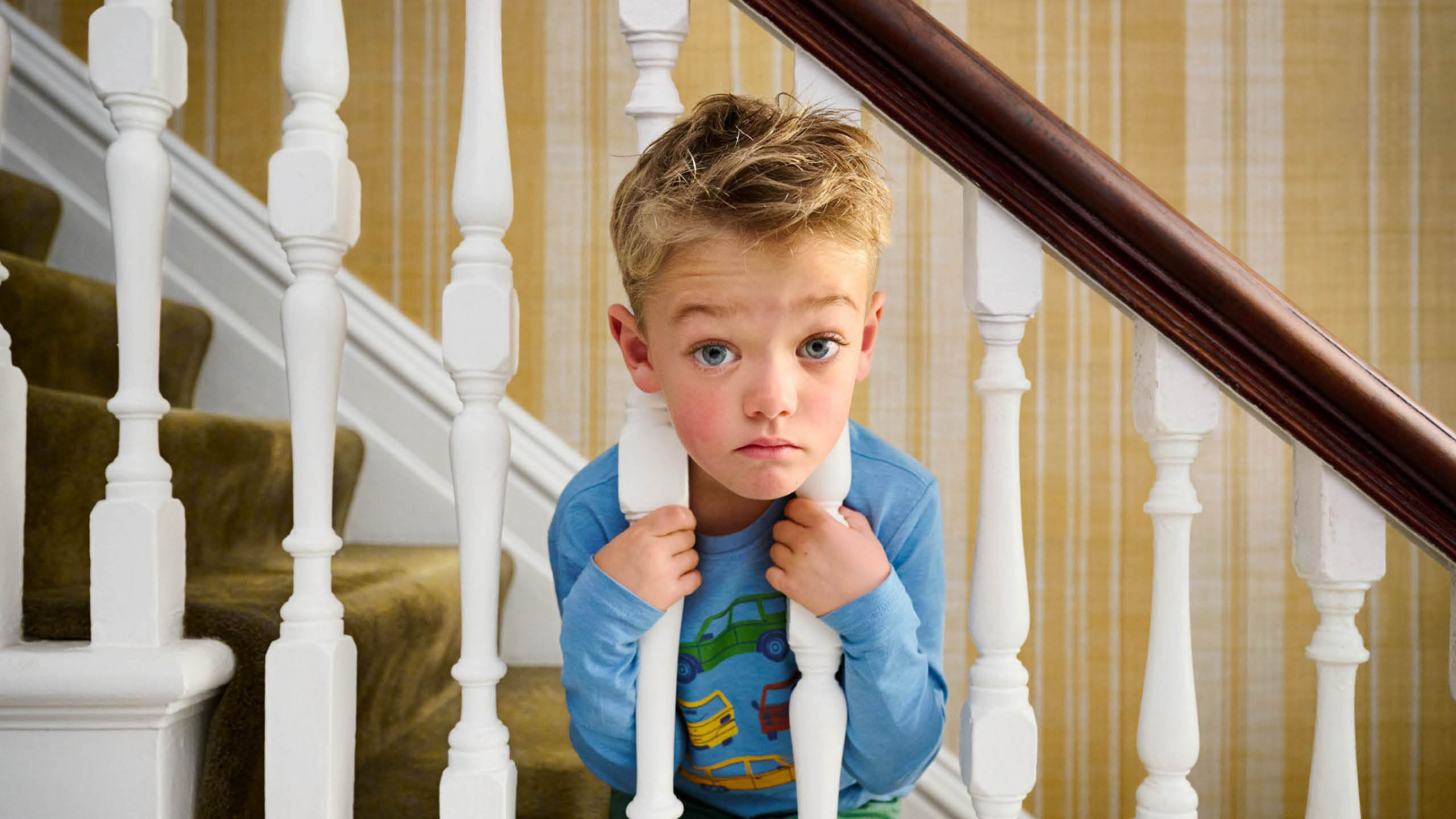 A still from the TVC, a boy with his head stuck in stair bannisters